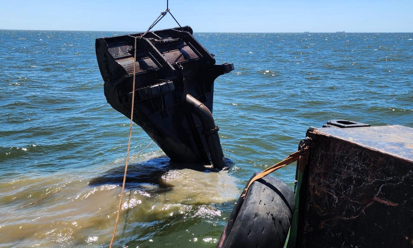 pieza de metal de gran tamaño atada a linga saliendo del agua