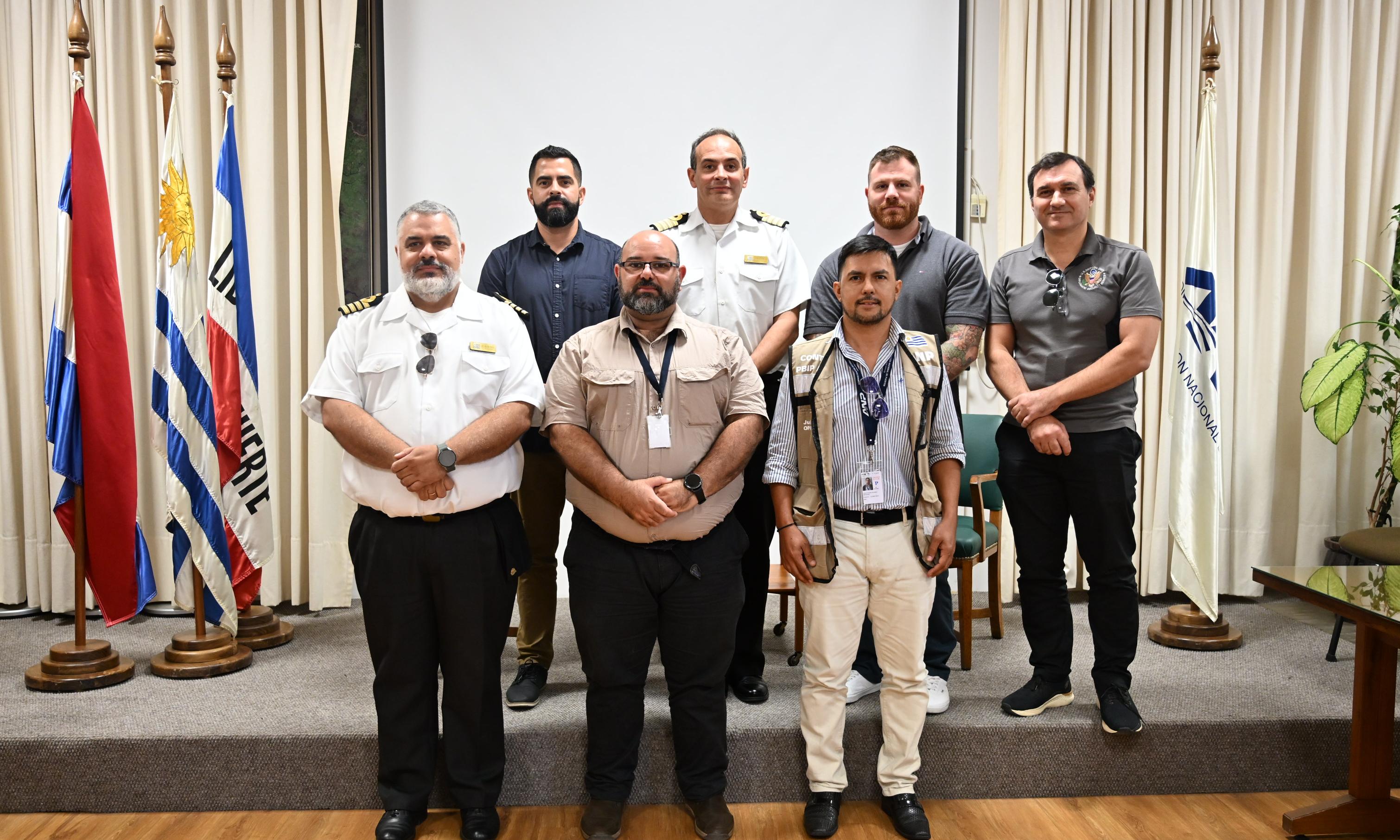 personas paradas en dos filas con banderas uruguayas a la izquierda